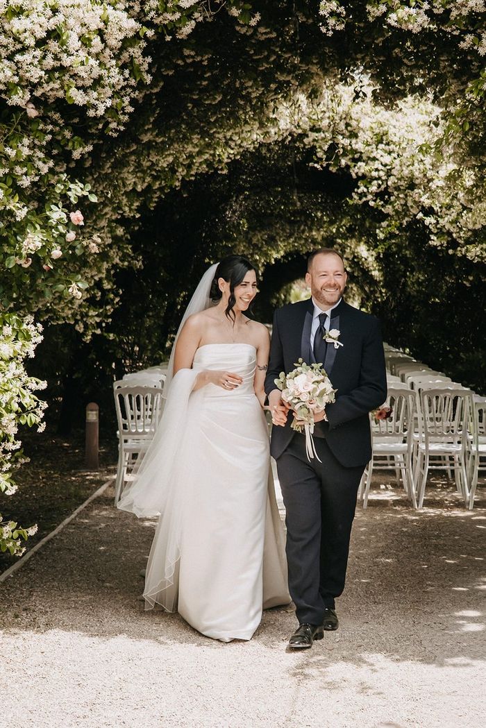 Sara e Alessandro il giorno del loro matrimonio, sotto un pergolato fiorito